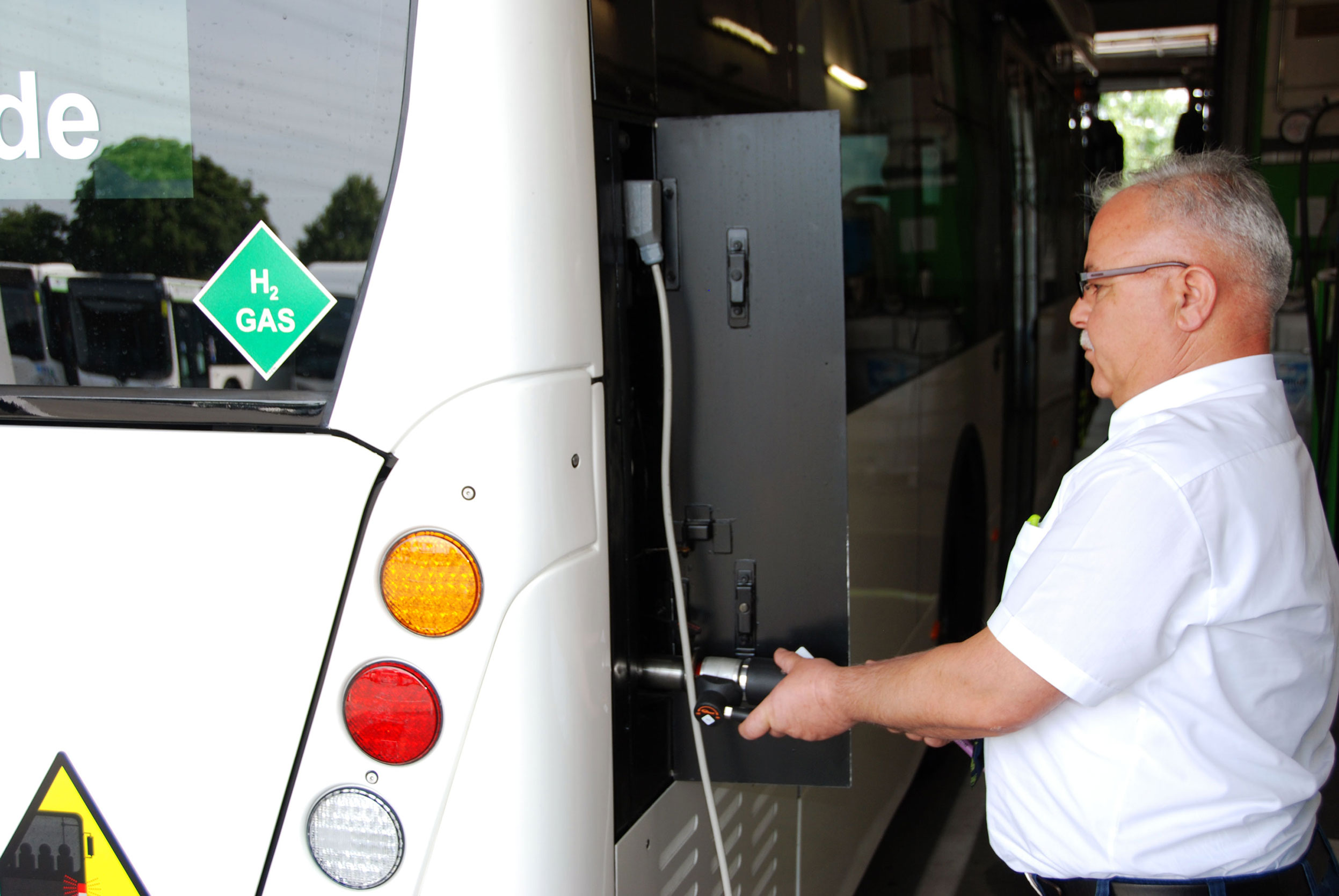 A person fueling a bus with hydrogen